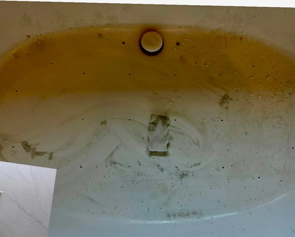 Tub with yellow staining and debris