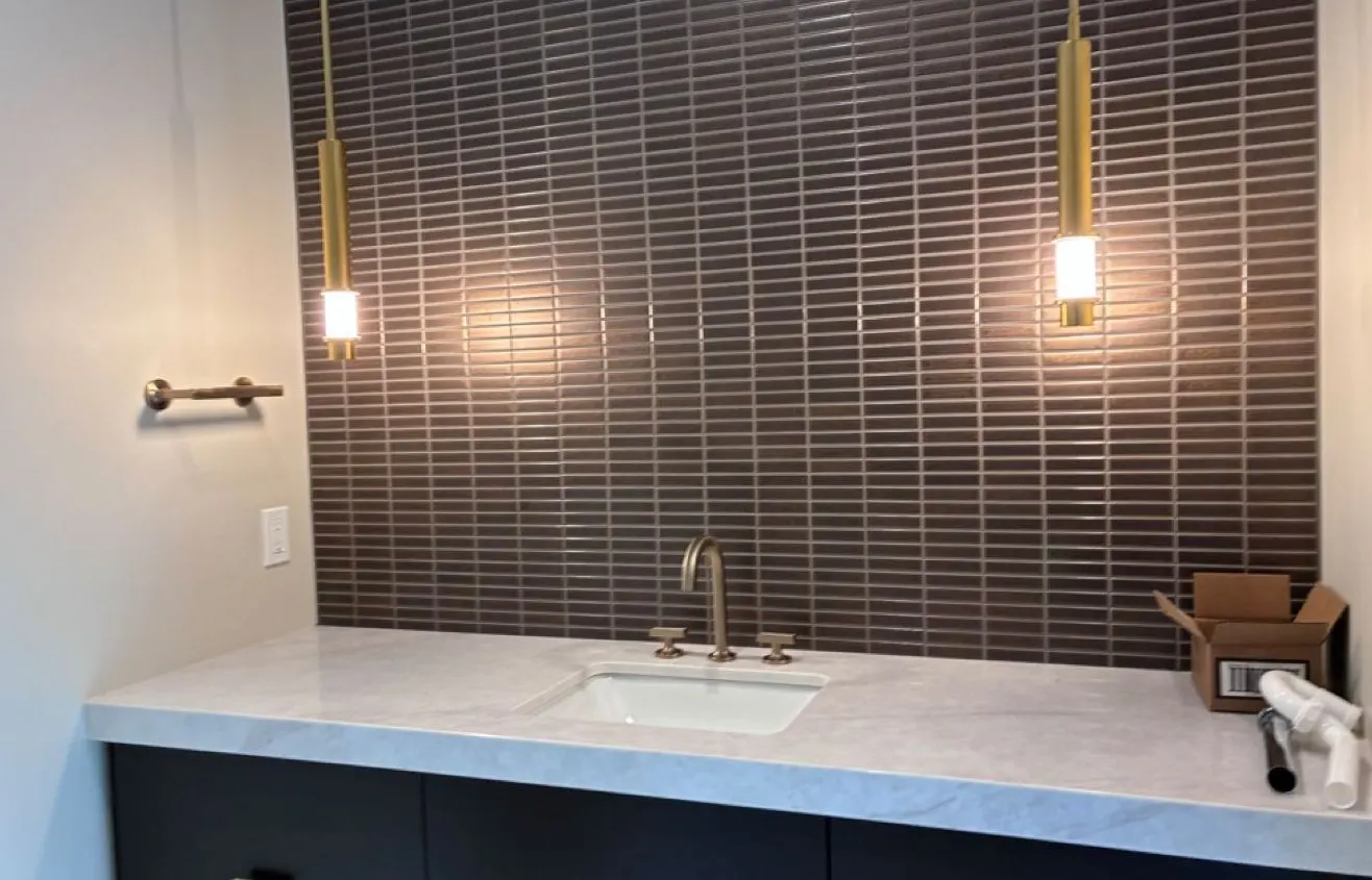 Clean bathroom vanity with polished counter and tile